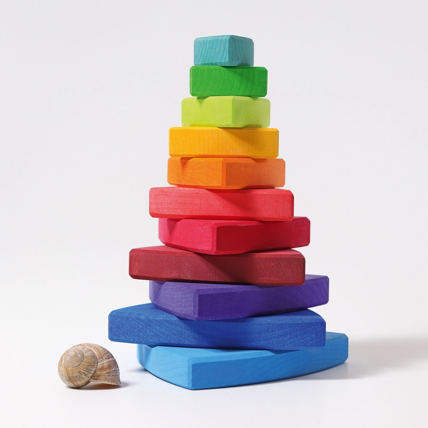 various rainbow coloured wooden pieces are stacked on top of each other