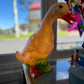 A duck shaped nightlight sits on a countertop.  The lamp is on and gives off a soft warm yellow glow.