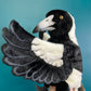 side view of black and white magpie bird puppet showing air brushed detailing on wings and beak