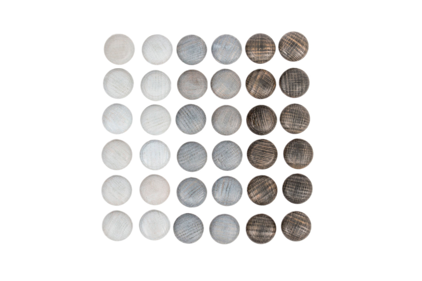 Grey wooden pebbles are arranged neatly in a sqare shape.  They are grouped by shade.