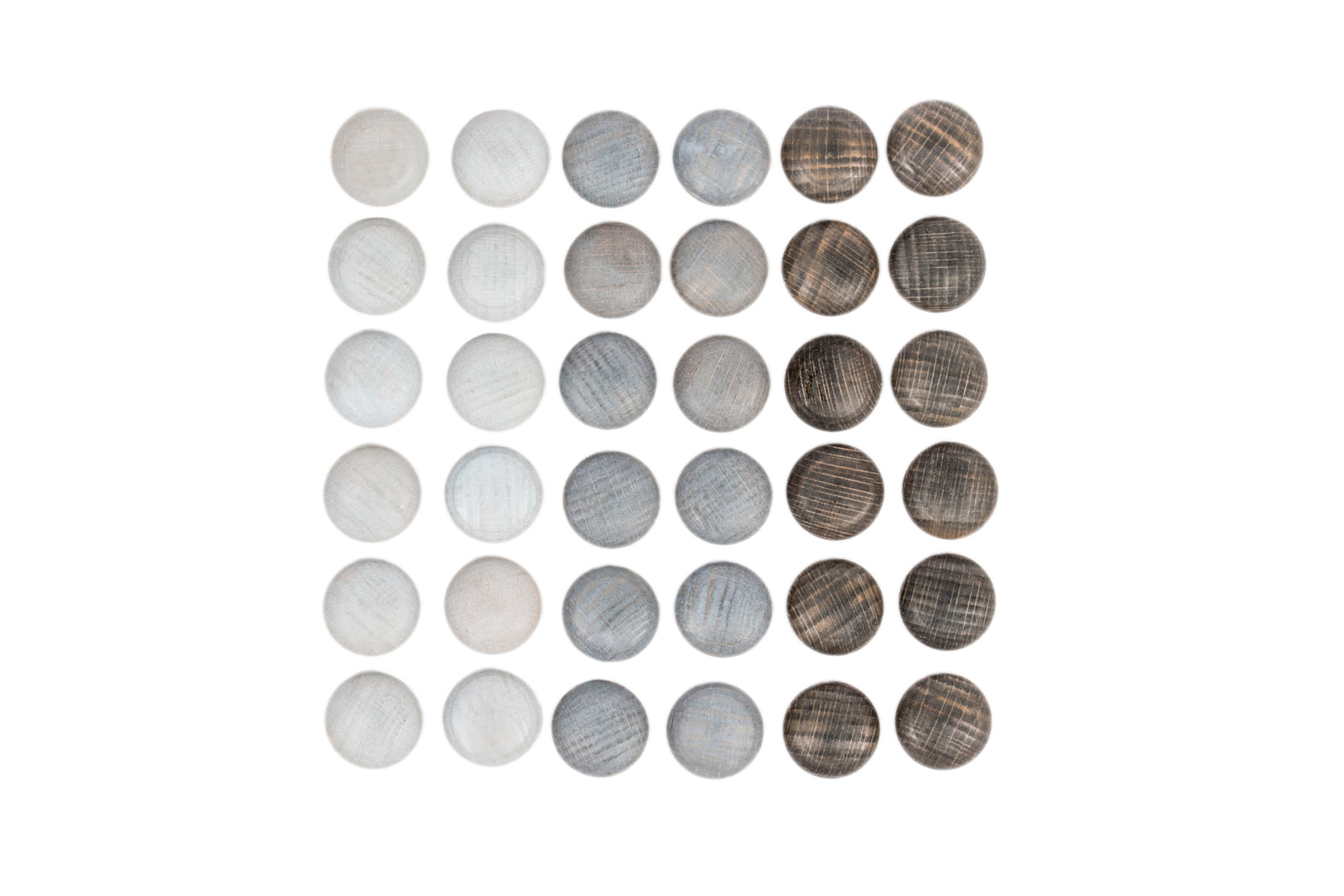 Grey wooden pebbles are arranged neatly in a sqare shape.  They are grouped by shade.