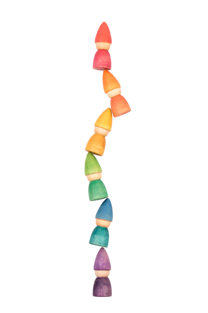 Wooden rainbow tomtens.  6 wooden carved people with cone shaped hats they are in a curved line on top of each other