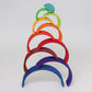 A wooden rainbow is stacked in a tower formation.