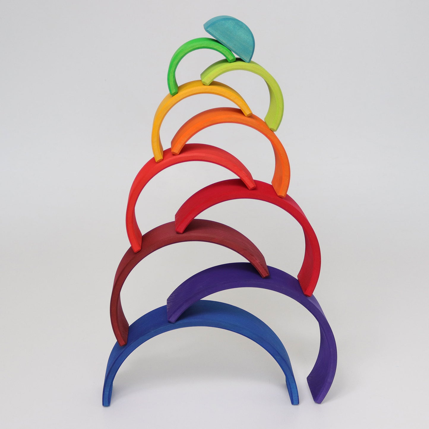 A wooden rainbow is stacked in a tower formation.